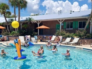 Guests playing volleyball in the outdoor pool at 55+ Holiday RV Park in Leesburg, FL.