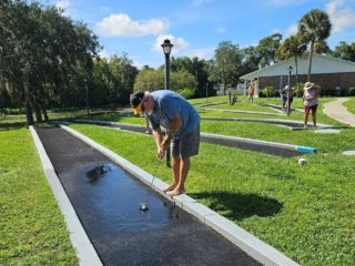 Guests playing mini golf at 55+ Holiday RV Park in Leesburg, FL.