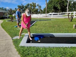 Guests playing mini golf at 55+ Holiday RV Park in Leesburg, FL.