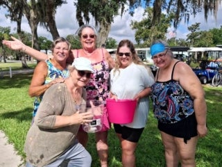Guests playing water games during Adult Twisted Summer camp event series at 55+ Holiday RV Park in Leesburg, FL.