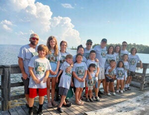 Parents, kids, and grandkids from the Rondeau family pose in their I Won It t-shirts overlooking Sebago Lake in Maine.