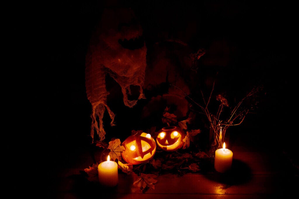 candles and jack-o'-lanterns in a dark room during Halloween.