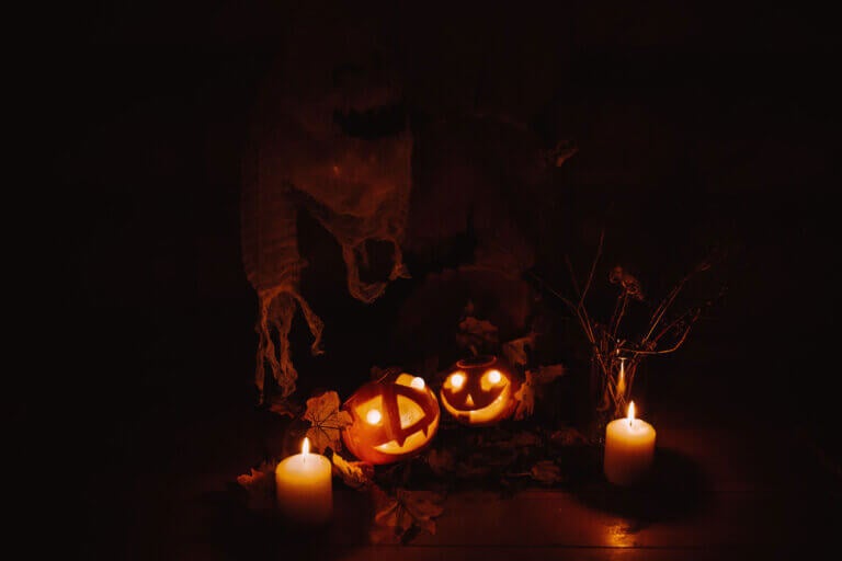 candles and jack-o'-lanterns in a dark room during Halloween.