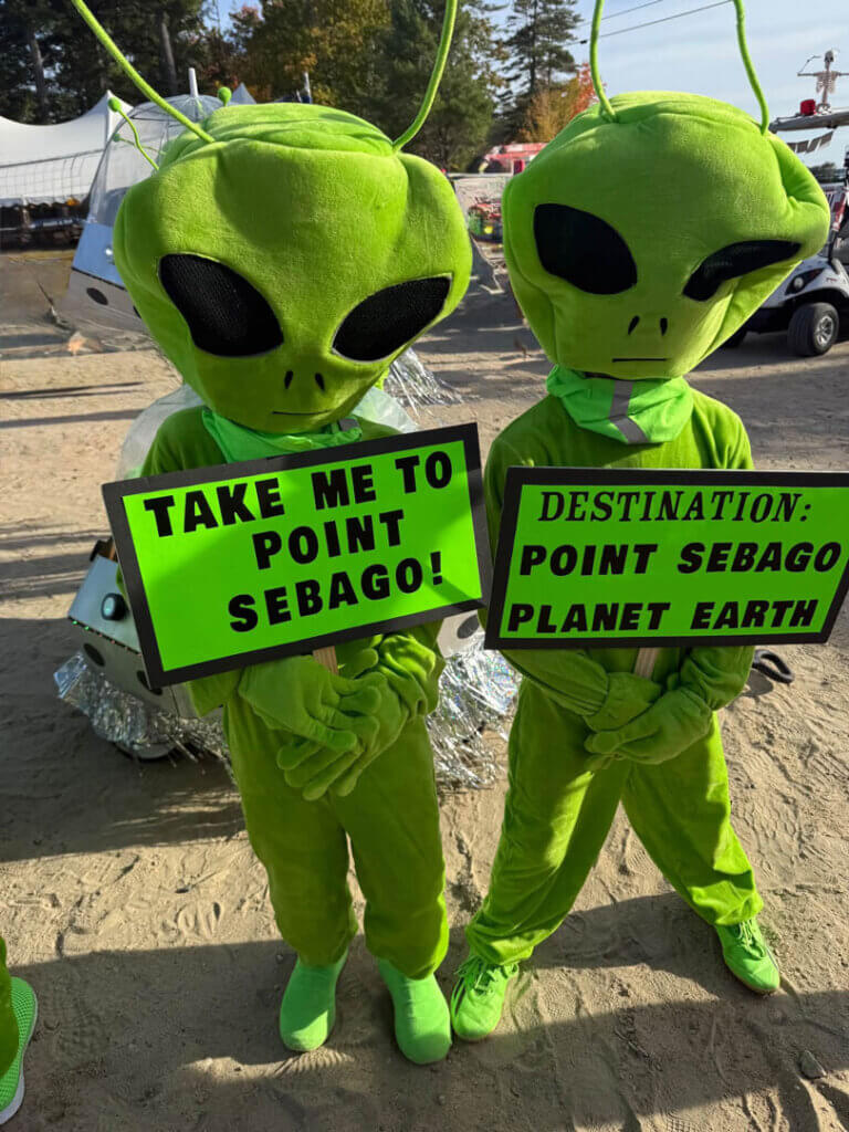 Two Dempsey grandkids dressed as aliens and holding signs at Point Sebago Resort in Casco, Maine.