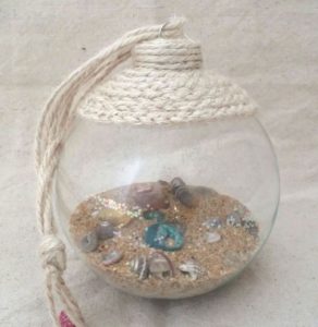 Glass ornament with sand and shells inside