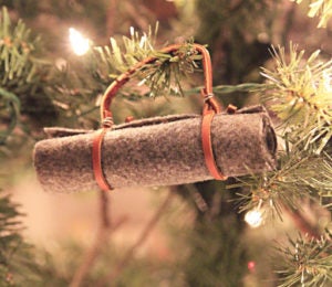 Felt bedroll camping ornament hanging on a Christmas tree