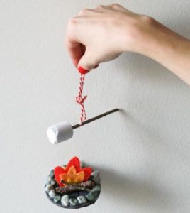 Felt campfire ornament hanging from a red string