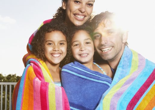 family wrapped in beach towels