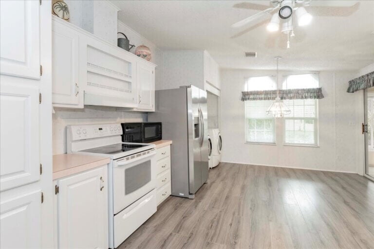 Interior view of the white kitchen and dining room at Cypress Lakes Village.