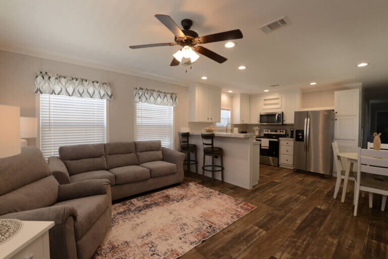 View. of a couch and kitchen inside a manufactured home with the address 6604 A Lakewood Dr