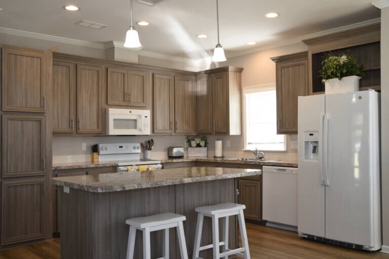View of the kitchen with island and two bar stools and kitchen appliances.